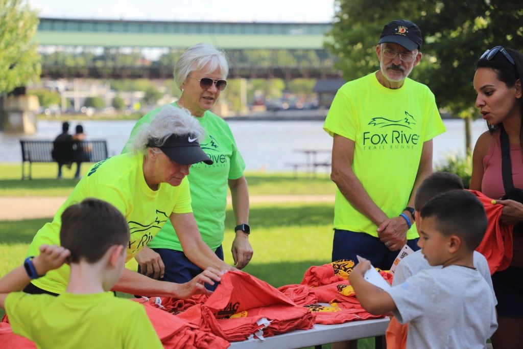 Volunteers in High Visibility Volunteer Shirts Help to Handout Shirts at the Great Western Half Marathon and 10K