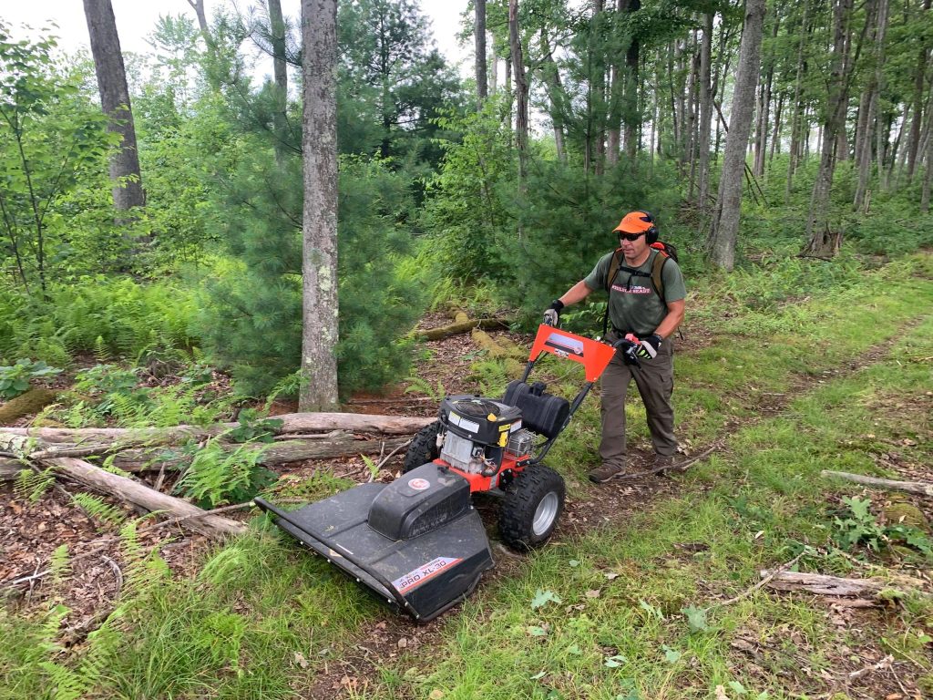 PA Trail Dog who adopted a trail, working at clearing, wearing a Racetrackers Hyner Hat.