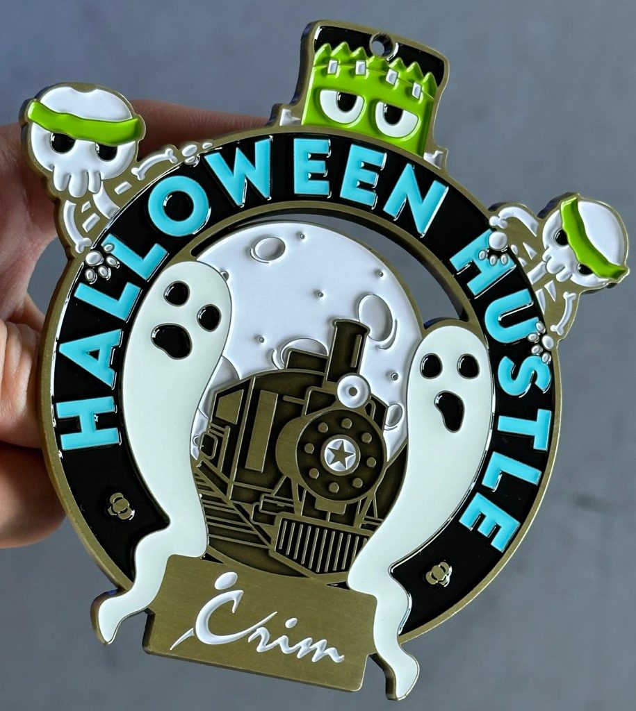 Halloween themed race medal for Crim Races and Events features glow in the dark ink.