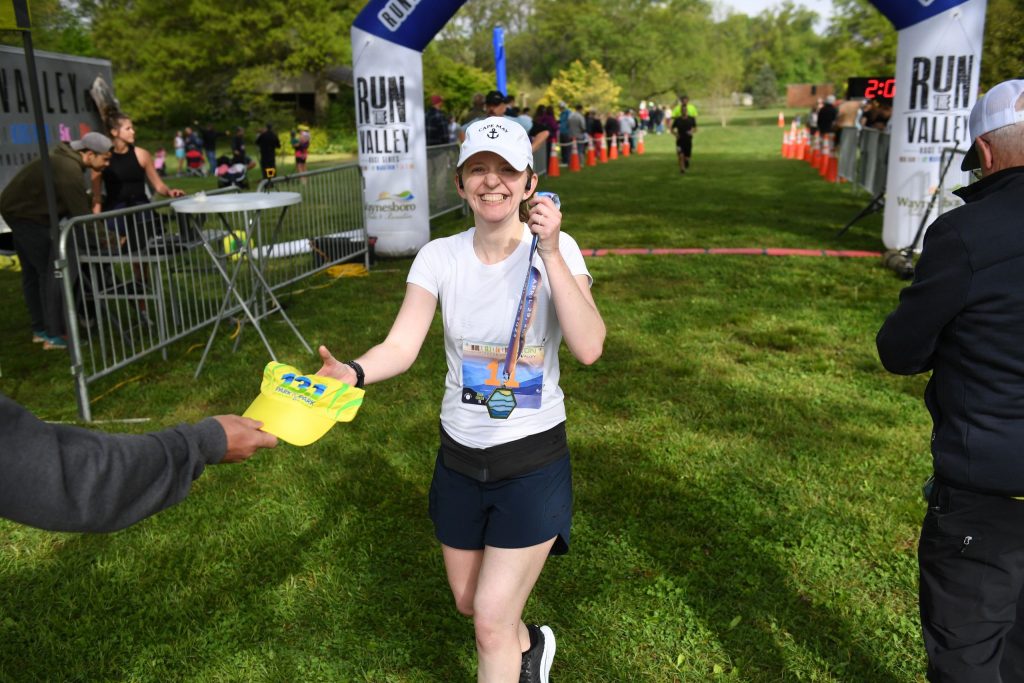 A half marathon finisher earns both a custom medal and a Racetrackers Run-dri hat at the finish line!